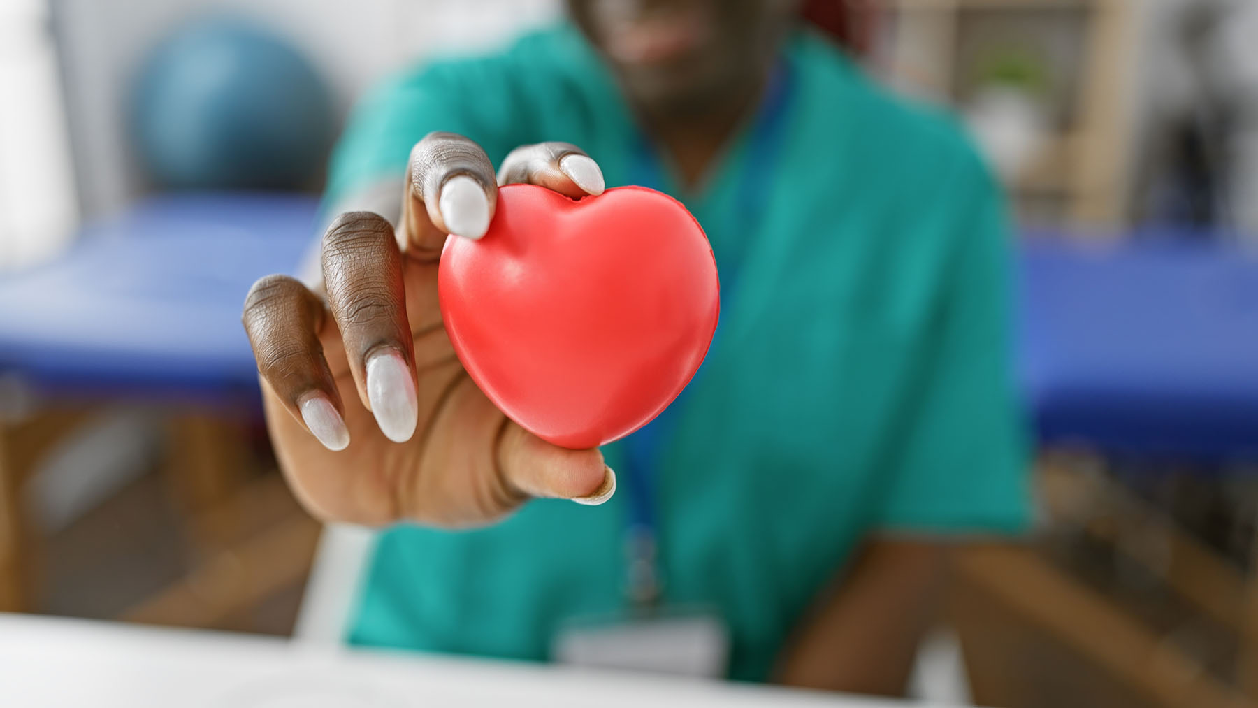 Medical professional holding a red heart